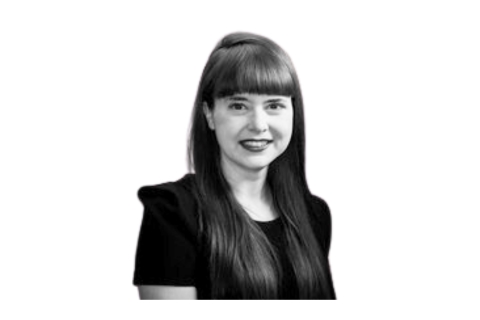 [ai] A woman with long, straight hair and bangs smiling. She is wearing a black top and is against a plain white background.